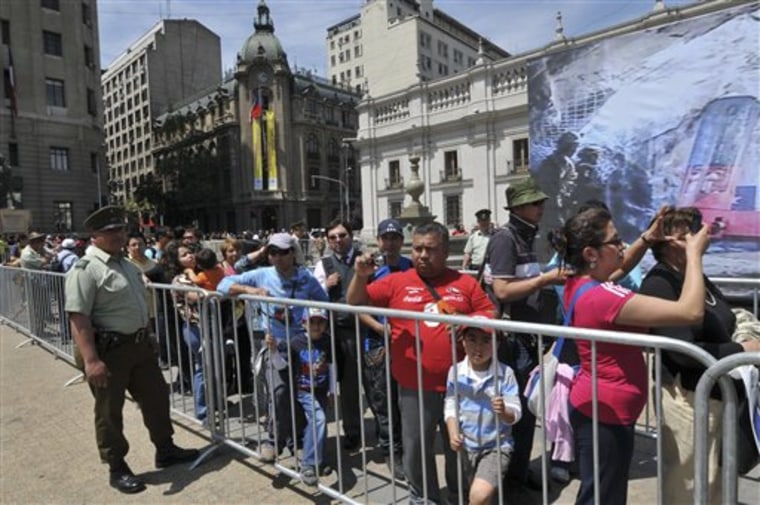 People wait in line to see the Phoenix 2 capsule, which lifted 33 trapped miners to the surface from the collapsed San Jose mine, as it is exhibited outside the government palace in Santiago on Tuesday, Oct. 19, 2010. 